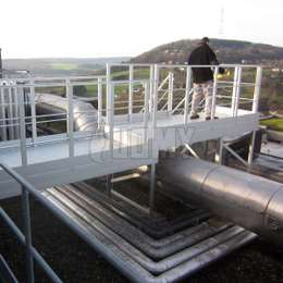 Freestanding walkway on a flat roof Aluminium walkway on a flat roof and used to walk over a pipe to a metal stair.